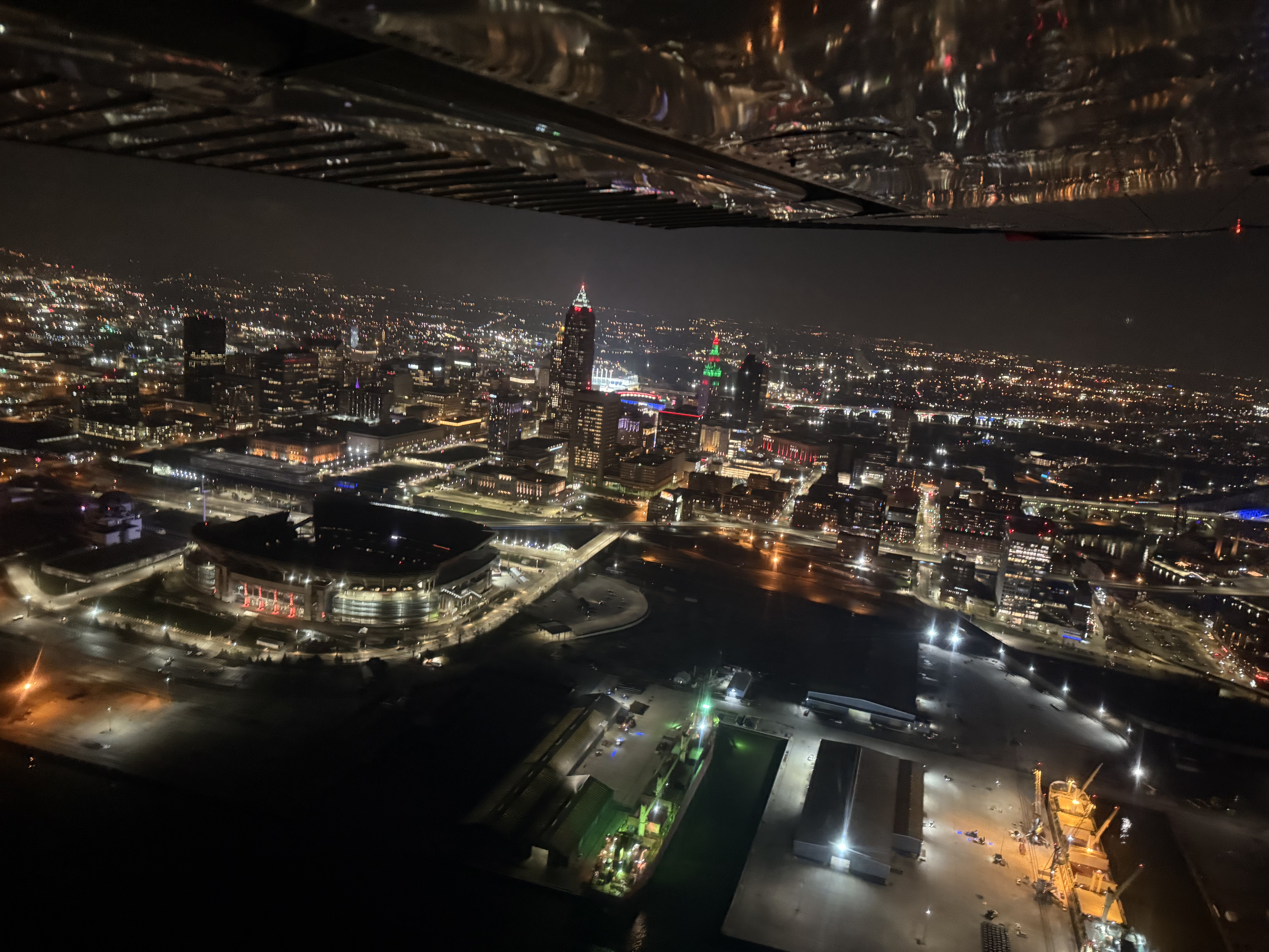 Cleveland at night from a high-wing, stadium and skyline under the wing